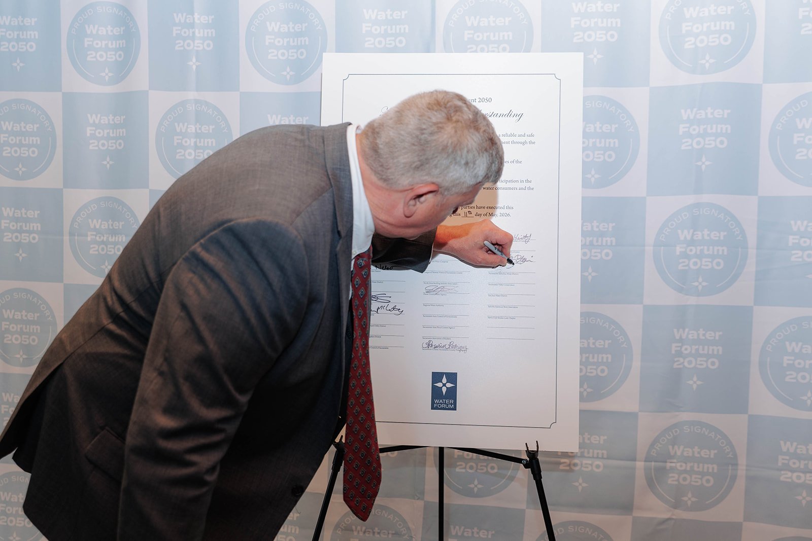 An SSWD representative signing the Water Forum Agreement 2050 Memorandum of Understanding on an easel.
